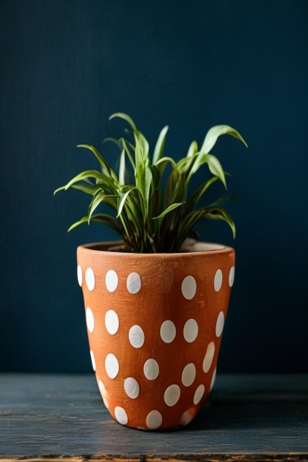 A cheerful scene featuring a terracotta pot adorned with crisp white polka dots against a dark blue background A small b
