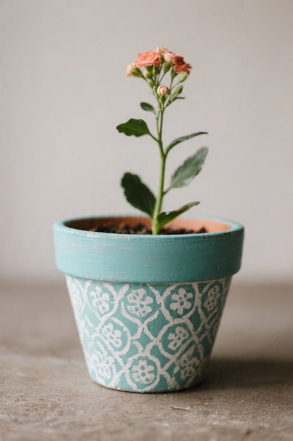 A painted flower pot with a delicate stenciled pattern in a contrasting color showing texture and detail The pot holds a