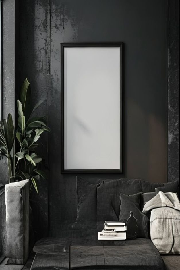 A close-up shot of a small solitary framed picture hanging noticeably too high above a large deep charcoal grey three-se