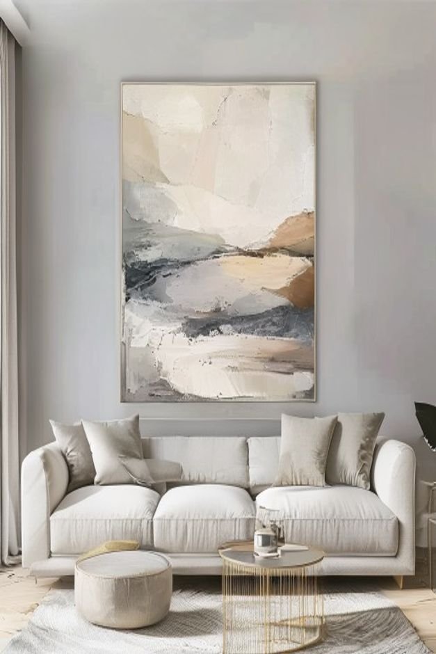 A perfectly scaled piece of abstract art in muted tones above a light grey sofa in a modern living room The art fills ab