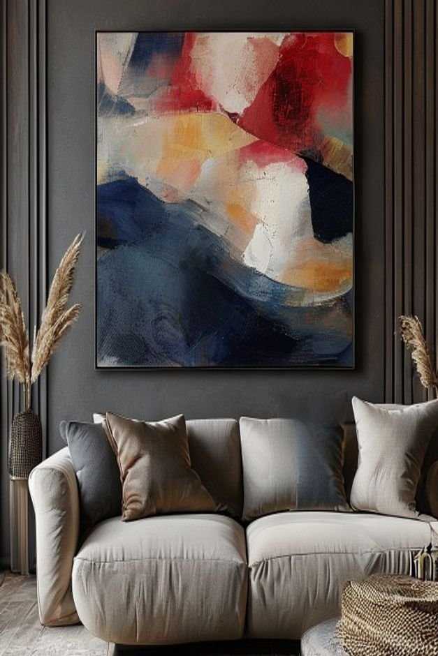 A close-up editorial shot focusing on a single oversized abstract painting hung above a deep-seated comfortable sofa The