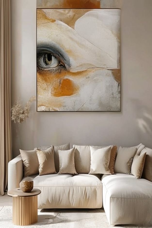 A close-up eye-level shot of a sophisticated living room wall above a neutral sofa A single oversized piece of abstract