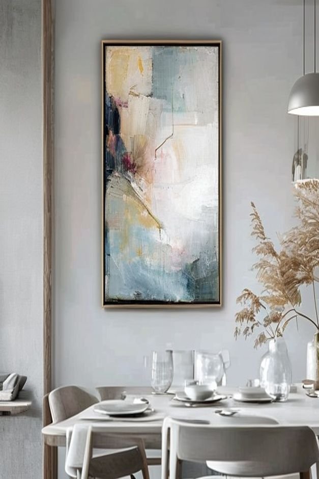 A close-up shot of a large framed abstract painting hanging on a light gray wall in a modern dining room The painting fe