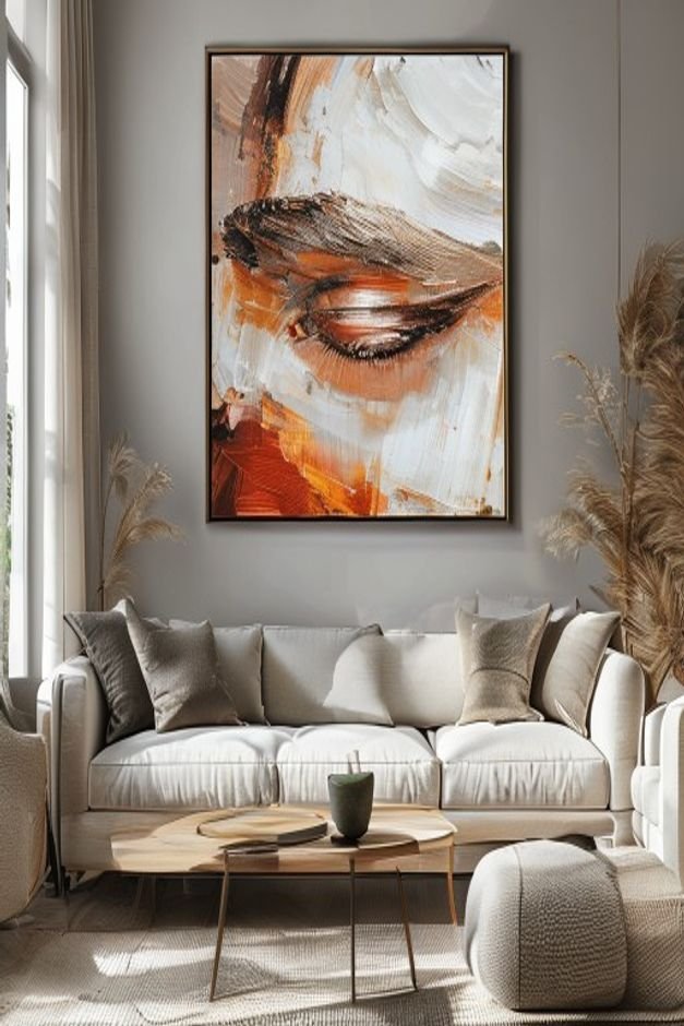 A close-up eye-level shot of a large framed abstract painting hanging above a contemporary sofa in a living room The art